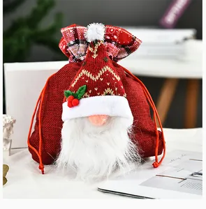 Detail van deze rode kerstkabouter cadeautas met een gebreide muts en pluchen baard
