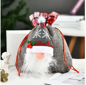 Detailweergave van een grijze linnen kerstkabouter geschenkzak met een gebreide muts