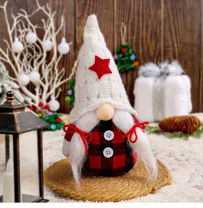 Detailed shot of a festive Christmas gnome with a star-patterned knitted hat in a snowy scene