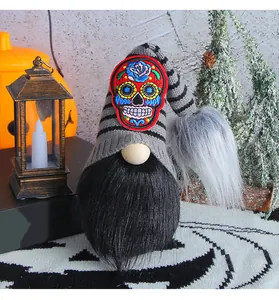 Vue détaillée d'un gnome d'Halloween avec un écusson coloré en forme de crâne en sucre.