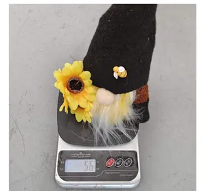 Vue détaillée d'une peluche de gnome abeille sur une balance indiquant un poids de 56g