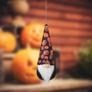 Detailed view of Halloween gnome ornament with pumpkin pattern hat in festive scene