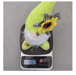 Figurine de gnome en peluche avec tournesol pesant 82 grammes sur une balance numérique