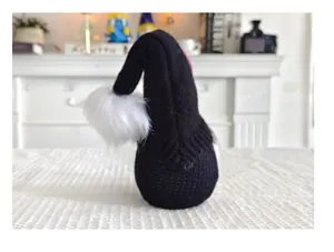 Vue arrière d'un gnome d'Halloween tricoté noir avec un pompon blanc doux et pelucheux