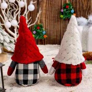 Two handmade festive Christmas faceless gnomes with buffalo plaid bodies and knit hats