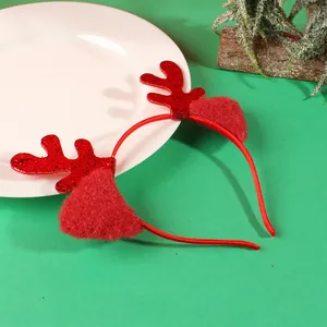 Cerchietto di Natale festivo con corna di renna rosse e orecchie di peluche su fondo verde