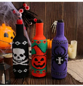 Close-up of Halloween knitted wine bottle covers with skull, pumpkin, and spider designs.