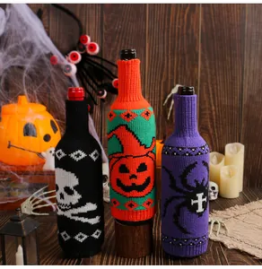 Detailed shot of Halloween knitted wine bottle covers with skull, pumpkin and spider motifs