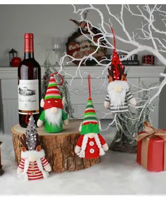 A collection of festive Christmas gnome plush ornaments displayed on a rustic wooden stump