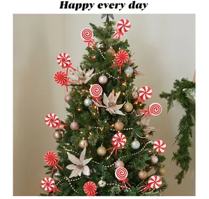 Festive red and white Christmas lollipop ornaments decorated on a lush green tree