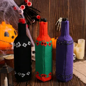 Set of Halloween knitted wine bottle covers featuring festive pumpkin and skull patterns