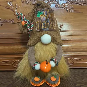 Detail view of a handcrafted Thanksgiving gnome plush doll holding an orange pumpkin