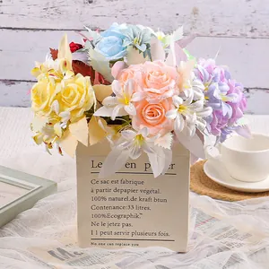 Elegante ramo de flores de seda artificiales de colores en una bolsa de papel decorativa