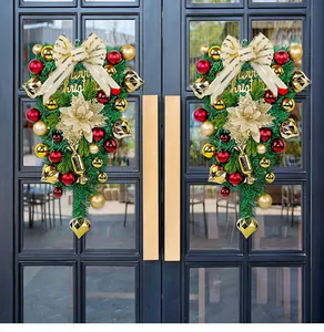 Detailed view of two Christmas swags with gold ornaments hanging on a black glass door.