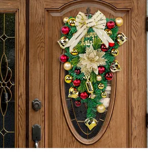 Festive Christmas teardrop swag with gold and red ornaments hanging on a wooden door