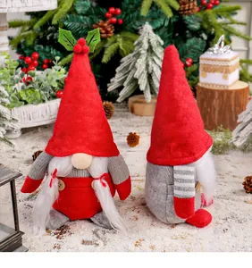 Close-up of two festive handmade Christmas gnomes standing in a snowy holiday scene