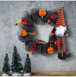 Halloween wreath detail with long-legged gnome doll and smiling pumpkins for festive door decor