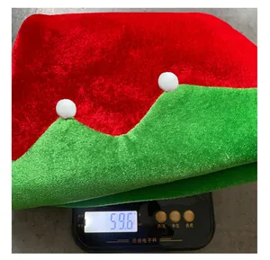 Detailed view showing the 59.6g weight of this red and green Christmas hat on a scale.
