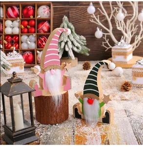 Macro view of two handmade wooden Christmas gnomes with white beards on wood logs