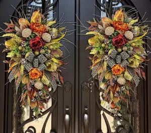 Detailed autumn door swags with orange peonies and leopard print ribbons for harvest decor.