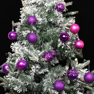 Purple Christmas ornament baubles with shiny and matte finishes on a snowy tree