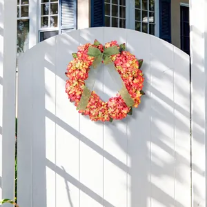 Ghirlanda di ortensie artificiali arancioni con fiocco verde per decorazione porta autunnale