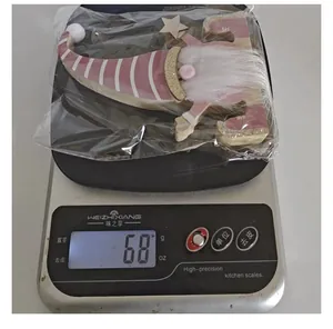 Close-up of a pink wooden Christmas gnome ornament on a digital scale weighing 68g
