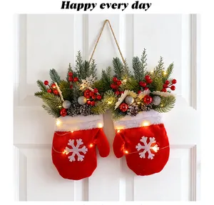 Détail d'une décoration murale festive de moufles de Noël avec lumières et baies rouges