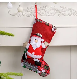 Detail view of red burlap Christmas stocking featuring 3D Santa Claus and plaid trim