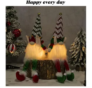 Detailed view of glowing Christmas gnome plush with knitted hats and warm fairy lights