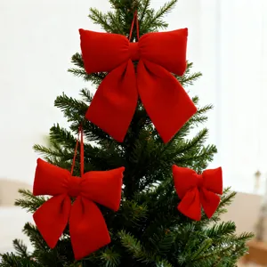 Grandi fiocchi di Natale in velluto rosso appesi a un albero per decorazione festiva