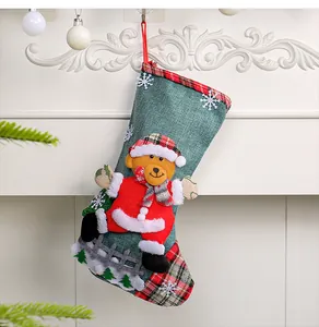 Festive green burlap Christmas stocking featuring a plush Santa bear and snowflake details