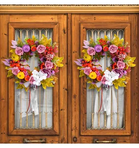 Herbst-Erntedank-Kränze mit Rosen und Kürbissen an rustikalen Holztüren aufgehängt