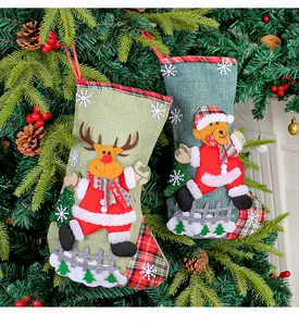 Detailed view of festive reindeer and bear linen Christmas stockings hanging on a tree
