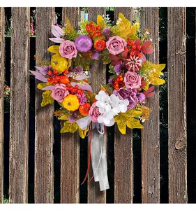 Detaillierte Ansicht des Erntedankkranzes mit Rosen, bunten Kürbissen auf Holz
