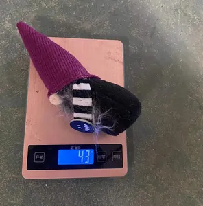 Gros plan montrant le poids léger de 43g du gnome d'Halloween avec chapeau violet