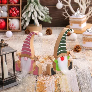 Pair of creative wooden Christmas gnomes with striped hats and fuzzy white beards