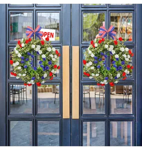 Two Fourth of July wreaths with patriotic ribbons hanging on a black glass front door