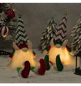 Pair of glowing Christmas gnomes with knit hats sitting in a snowy forest scene