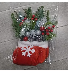 Détail d'une décoration de gant de Noël festif avec pins et baies artificiels