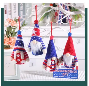 Detail of four USA Independence Day knitted gnome ornaments hanging on a branch