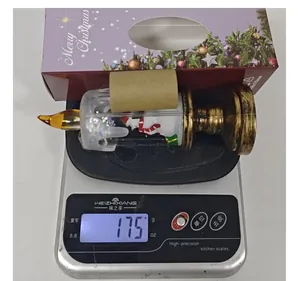 Christmas candle snow globe night light with snowman weighing 175g on a digital scale.
