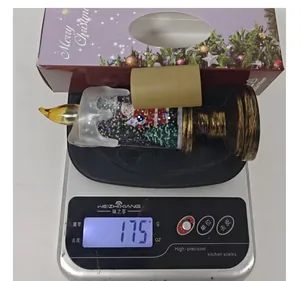 Weight measurement of the Christmas candle snow globe night light, showing 175 grams.