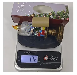 Detail view of the Christmas snow globe LED candle light showing a weight of 172g on a scale