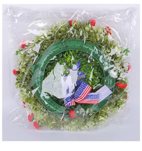 Patriotic Independence Day wreath with red roses and American flag ribbon in packaging
