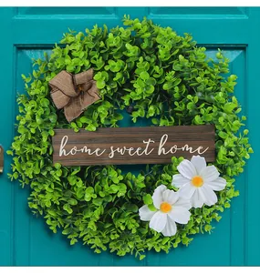 Close-up of green eucalyptus wreath with white daisies and home sweet home sign