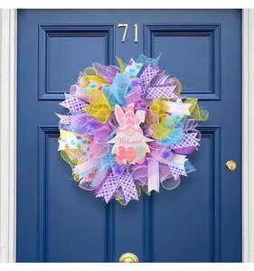 Detailansicht des bunten Osterkranzes mit Gnom und Welcome-Schild an einer blauen Tür