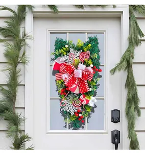 Close-up of a festive Christmas inverted wreath hanging on a white door with candy decor