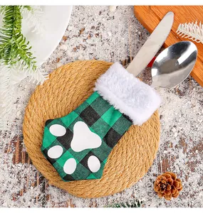 A detailed close-up of a festive plaid cat paw cutlery holder on a rustic Christmas table