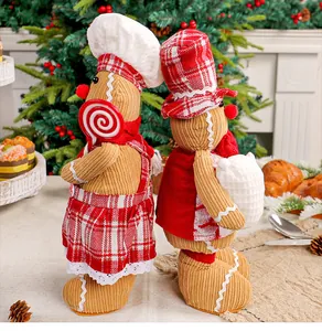 Pärchen festlicher Lebkuchenmann-Plüschpuppen mit Kochmützen für Weihnachtsdekoration.